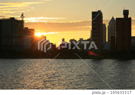 朝日に輝くビルと湖に浮かぶ船 朝日に輝くビルと湖に浮かぶ船 105635517
