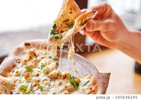 one people takes slices of pizza. Neapolitan pizza from a wood-fired oven. Pizza is on the plate. Pizza with pear and gorgonzola. Fast delivery of food. one people takes slices of pizza. Neapolitan pizza from a wood-fired oven. Pizza is on the plate. Pizza with pear and gorgonzola. Fast delivery of food. 105636245