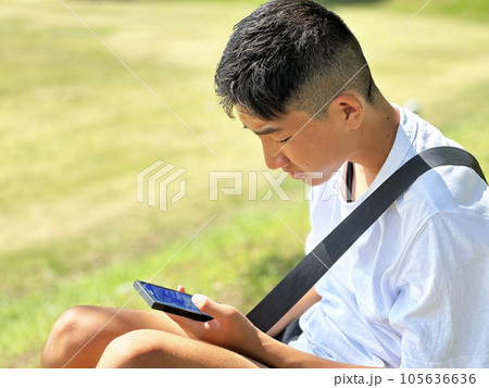 スマートフォンでゲームをする少年 105636636