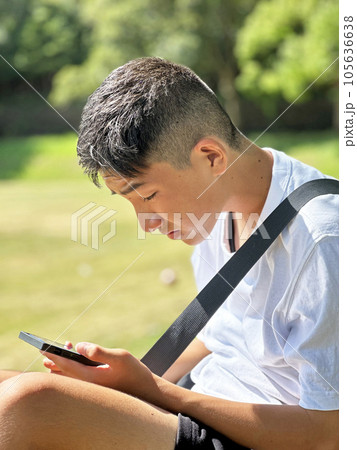 スマートフォンでゲームをする少年 105636638