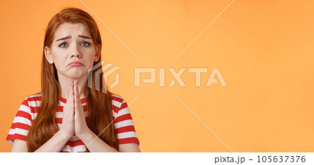 Pity uneasy redhead girl pull sad face, quivering lip upset, begging mercy, apologizing, plead help, press palms pray gesture, frowning hopeless, asking and begging favour, stand orange background Pity uneasy redhead girl pull sad face, quivering lip upset, begging mercy, apologizing, plead help, press palms pray gesture, frowning hopeless, asking and begging favour, stand orange background 105637376
