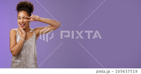 Sassy elegant confident african-american woman in stylish silver dress touch cheek show peace victory gesture feel lucky self-assured wear luxurious dress attend wealthy party, blue background 105637519