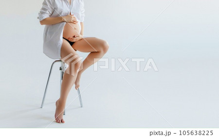 pregnant body. pregnant girl sitting on the white 105638225