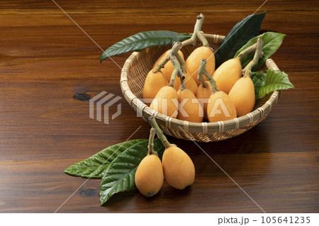 ざるに入れて葉を添えたびわ 105641235