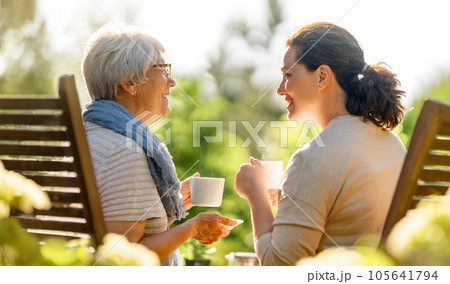 women drinking tea in the garden women drinking tea in the garden 105641794