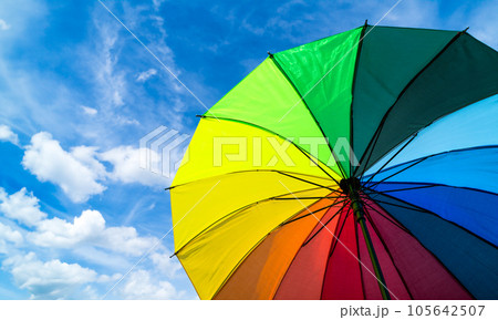 Colorful rainbow umbrella on blue sky background. LGBT, Pride Month, diversity, Sunprotect Concept. Colorful rainbow umbrella on blue sky background. LGBT, Pride Month, diversity, Sunprotect Concept. 105642507