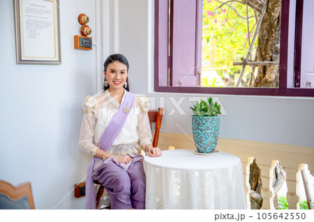Beautiful Asian woman with contemporary Thai dress sit with old furniture in public ancient house 105642550