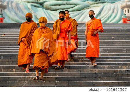 Group of young and senior monks walk down from area of big buddha statue with day light. Group of young and senior monks walk down from area of big buddha statue with day light. 105642597