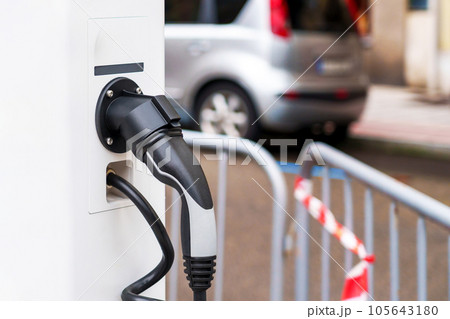 Electric plug of green renewable energy car charging station in the city Electric plug of green renewable energy car charging station in the city 105643180