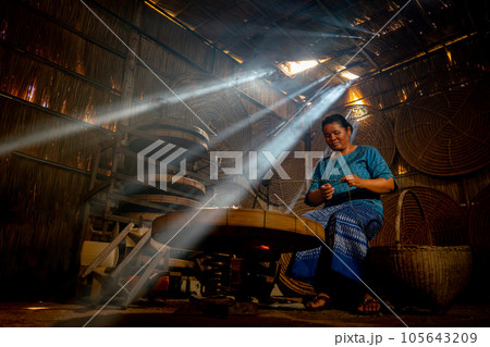 Asian young senior woman prepare raw material silk in room with beam of sunlight and work alone Asian young senior woman prepare raw material silk in room with beam of sunlight and work alone 105643209