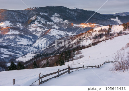 carpathian rural landscape i winter. wooden fence on the snow covered hill. bright sunny day 105643458