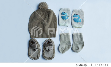 Complete brown baby fashion accessories from knitted hat, socks, knee pad socks, and shoes isolated on white background. Complete brown baby fashion accessories from knitted hat, socks, knee pad socks, and shoes isolated on white background. 105643834