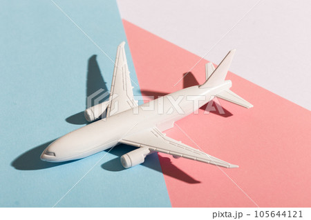 Model plane airplane on pastel blue and pink color background. Flat lay design. Flight and aircraft concept Model plane airplane on pastel blue and pink color background. Flat lay design. Flight and aircraft concept 105644121