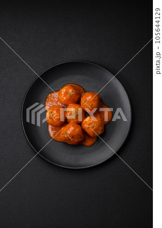 Delicious fresh meatballs in tomato sauce with salt, spices and herbs Delicious fresh meatballs in tomato sauce with salt, spices and herbs 105644129