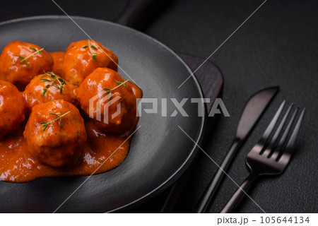 Delicious fresh meatballs in tomato sauce with salt, spices and herbs Delicious fresh meatballs in tomato sauce with salt, spices and herbs 105644134