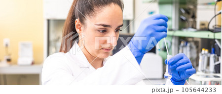 Young woman scientist in a research laboratory creating a scientific experiment, laboratory concept 105644233