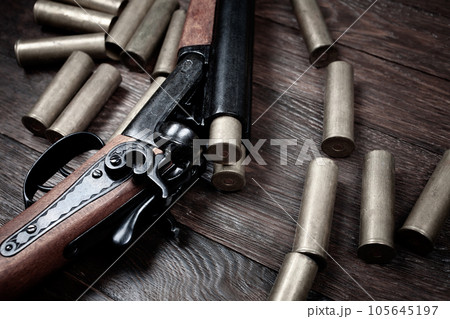 Vintage retro double-barreled hunting shotgun with brass cartridges Vintage retro double-barreled hunting shotgun with brass cartridges 105645197