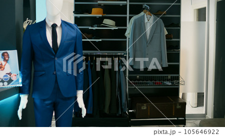 Empty clothing store filled with racks and hangers, elegant formal wear hanging in shopping mall retail boutique. Fashion shop with merchandise on sale, tailoring small business concept. 105646922