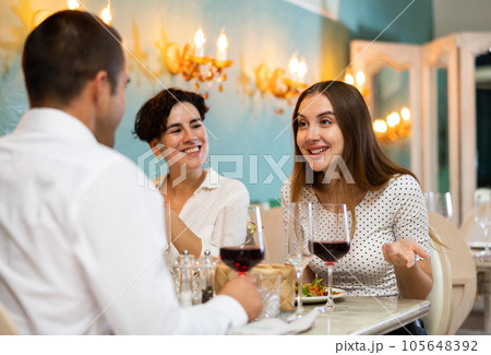 Group of satisfied friends enjoying evening meal at restaurant Group of satisfied friends enjoying evening meal at restaurant 105648392