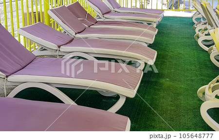 Free deck chairs stand in a row, empty beach chairs are waiting for tourists 105648777