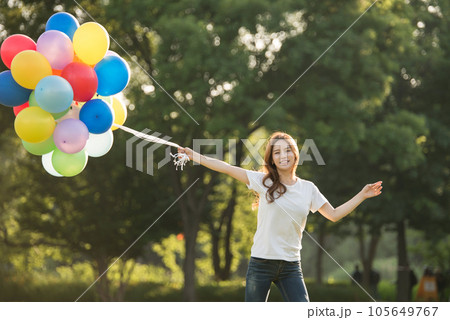 smiling woman with colorful balloons outdoors 105649767