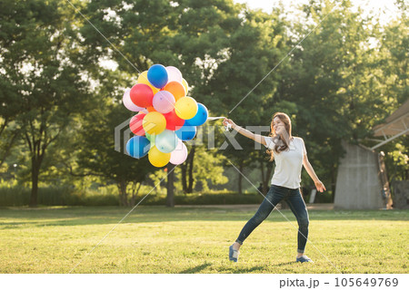 smiling woman with colorful balloons outdoors smiling woman with colorful balloons outdoors 105649769