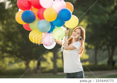 smiling woman with colorful balloons outdoors 105649775