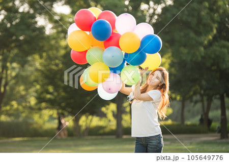 smiling woman with colorful balloons outdoors 105649776