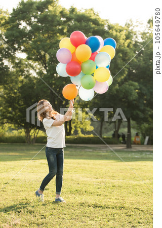 smiling woman with colorful balloons outdoors smiling woman with colorful balloons outdoors 105649780