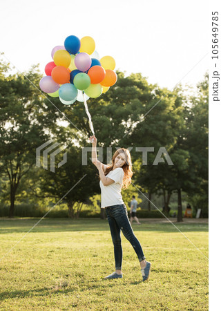 smiling woman with colorful balloons outdoors smiling woman with colorful balloons outdoors 105649785