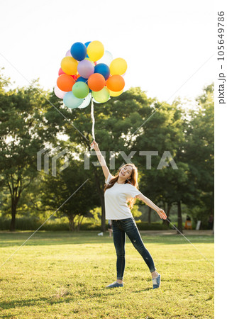 smiling woman with colorful balloons outdoors smiling woman with colorful balloons outdoors 105649786