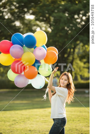 smiling woman with colorful balloons outdoors 105649788