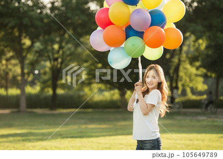 smiling woman with colorful balloons outdoors 105649789