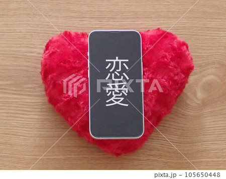 ハートの上にあるスマホの画面に恋愛の文字 ハートの上にあるスマホの画面に恋愛の文字 105650448