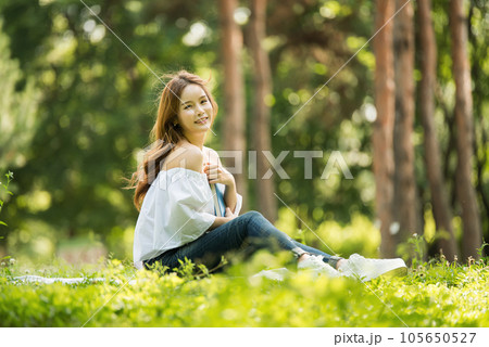 a beautiful young woman reading a book in the park a beautiful young woman reading a book in the park 105650527