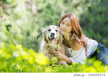 a happy young woman taking a walk with her dog in the park a happy young woman taking a walk with her dog in the park 105650573