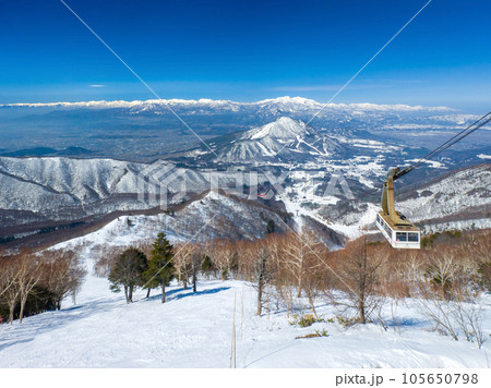 スキー場ロープウェイ山頂駅から見下ろす急斜面コースと山並み (長野県、竜王スキーパーク) 105650798