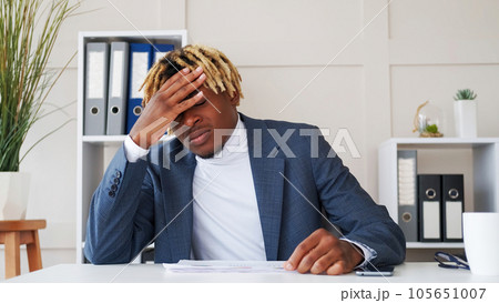 Work fail. Business problem. Frustrated with mistake tired man entrepreneur in stress head on hand facepalm gesture at modern office workplace. 105651007