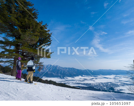 スキー場から雪に覆われた町並みを見渡すスノーボーダー達 (福島県、猪苗代スキー場) 105651097