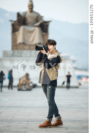 A young man holding a camera and taking pictures during a trip to Korea A young man holding a camera and taking pictures during a trip to Korea 105651270