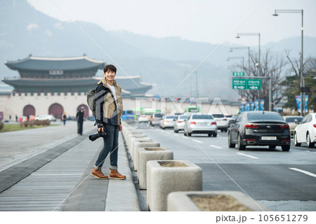 A young man holding a camera and taking pictures during a trip to Korea	 105651279
