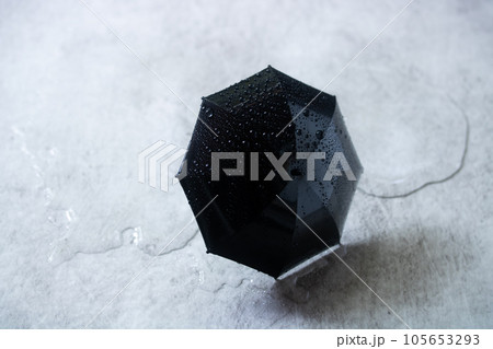 雨・水溜まりと雨傘 105653293