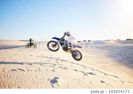 Motorcycle, desert race and jump in air for competition, stunt and outdoor for performance, goal and speed. Motorbike athlete, dunes and ramp in nature, sand and together for training in mockup space Motorcycle, desert race and jump in air for competition, stunt and outdoor for performance, goal and speed. Motorbike athlete, dunes and ramp in nature, sand and together for training in mockup space 105654171
