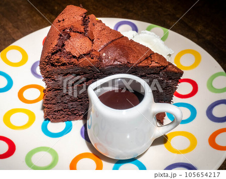 Chocolate brownies cake with chocolate sauce on top and whip cream on colorful dish 105654217