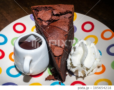 Chocolate brownies cake with chocolate sauce on top and whip cream on colorful dish 105654218