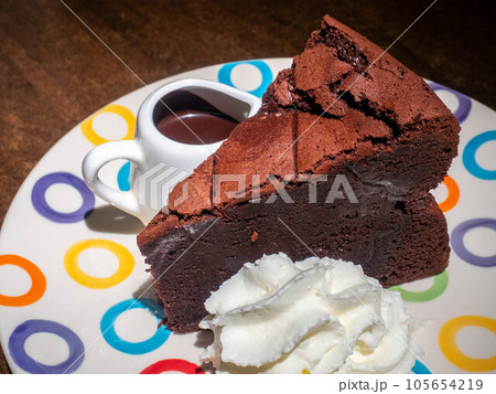 Chocolate brownies cake with chocolate sauce on top and whip cream on colorful dish 105654219