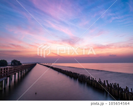 Sea view near mangrove forest with man made wooden barrier for wave protection, under morning twilight colorful sky 105654564