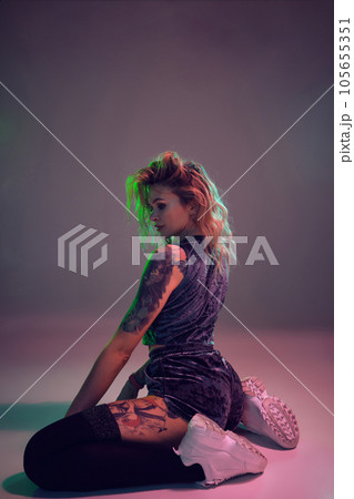 beautiful caucasian blonde girl in velour blue booty shorts and black stockings dancing twerk lying down on pink background beautiful caucasian blonde girl in velour blue booty shorts and black stockings dancing twerk lying down on pink background 105655351