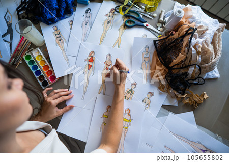 Woman drawing sketches of swimwear and underwear in watercolor.  105655802