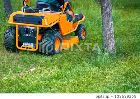 Professional grass cutting on lawns with a mini tractor lawn mower. Professional grass cutting on lawns with a mini tractor lawn mower. 105659259